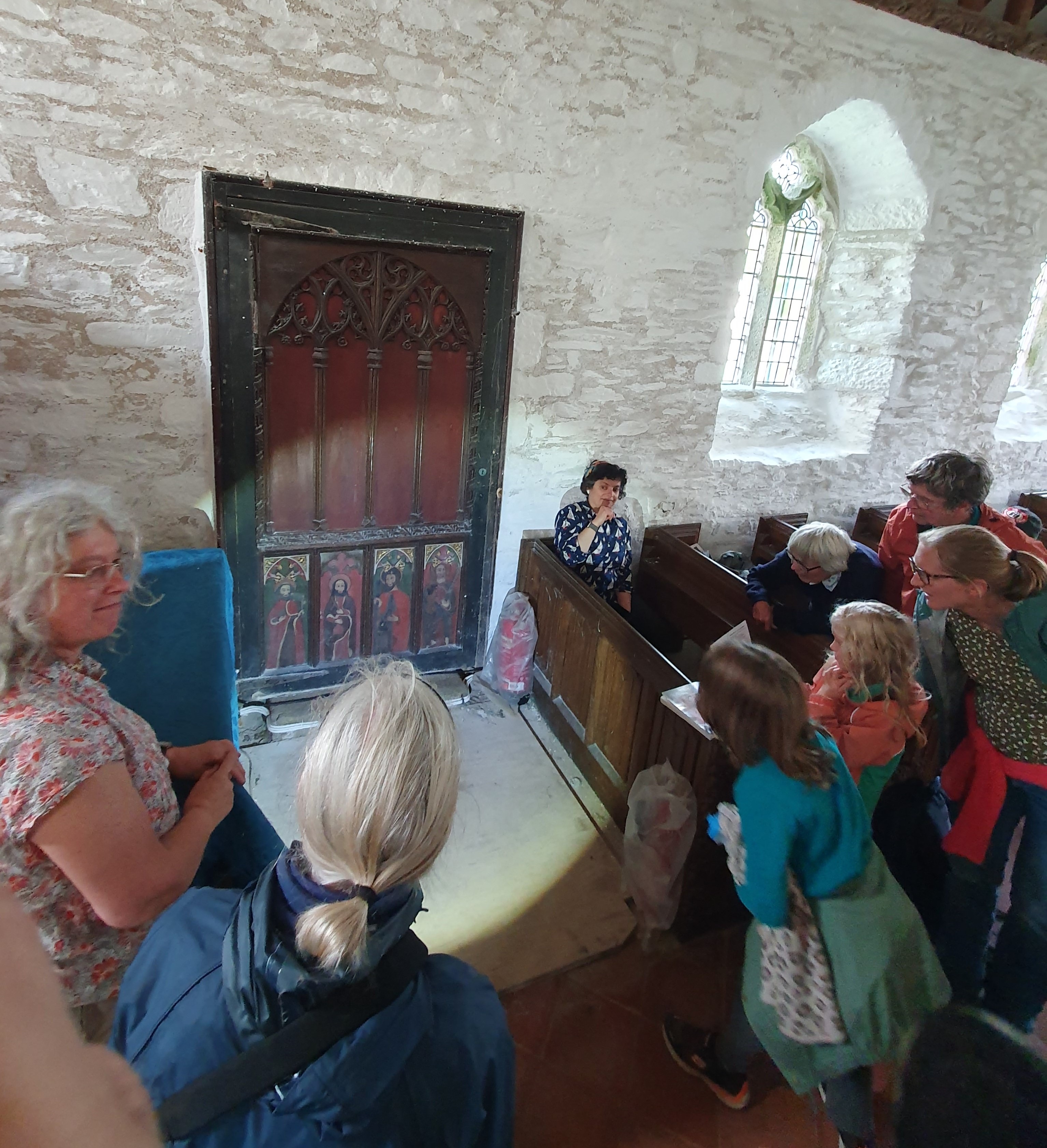 The torch beam highlights the ornamental screen panels as part of the exploration of their origins. The panels form the base of the dark painted door set in the whitewashed north wall.